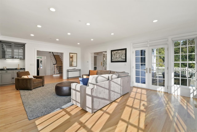 living room with stairs, recessed lighting, french doors, and light wood finished floors