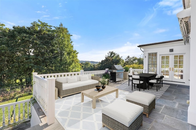 view of patio with an outdoor living space, area for grilling, and french doors