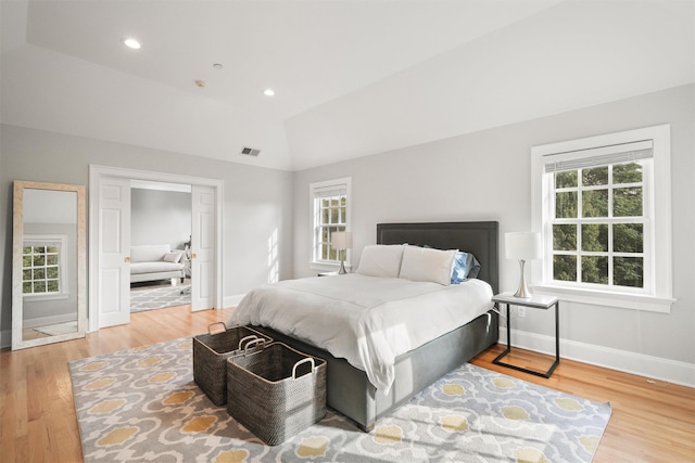 bedroom featuring visible vents, multiple windows, and wood finished floors