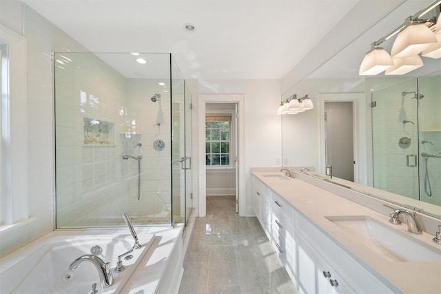 full bath with double vanity, a shower stall, a jetted tub, and a sink