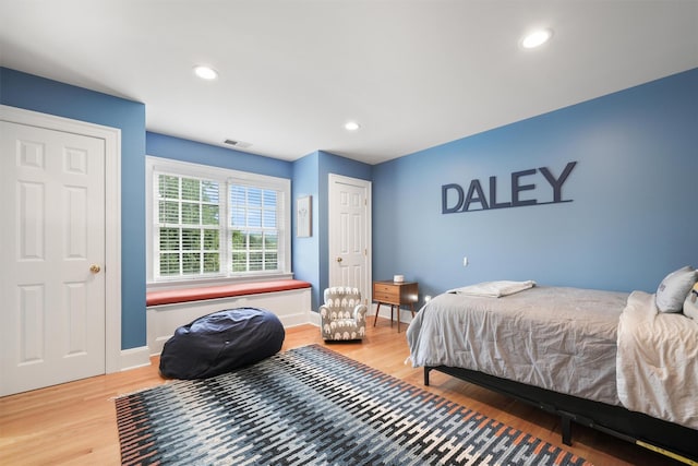 bedroom with recessed lighting, light wood-type flooring, baseboards, and visible vents