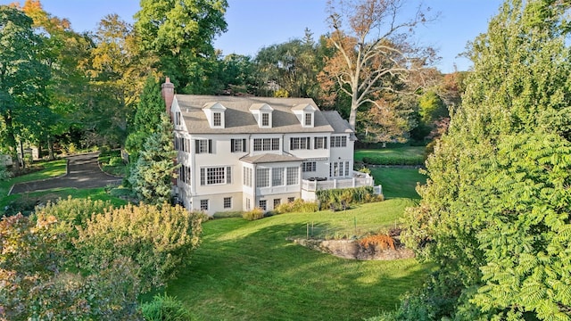 rear view of property with a lawn and a chimney