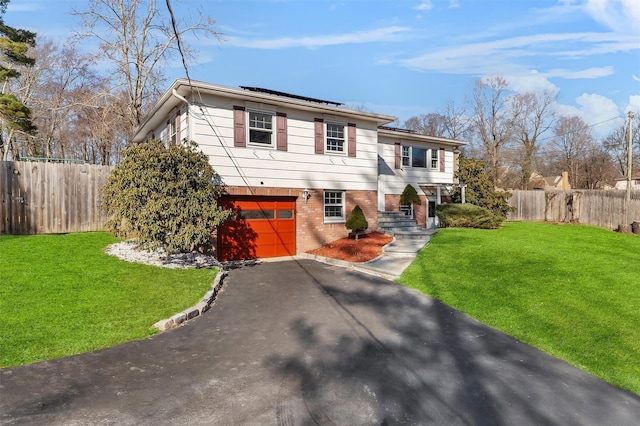 view of front of property featuring brick siding, solar panels, a front lawn, and fence