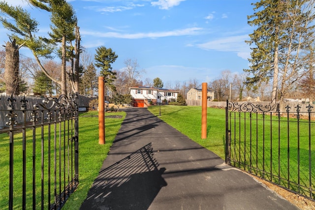 view of front facade with a fenced front yard, a front lawn, and a gate