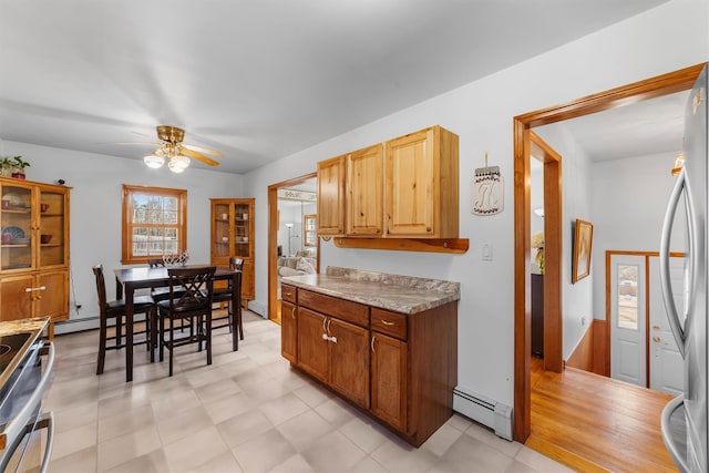 kitchen with light countertops, baseboard heating, stainless steel appliances, a ceiling fan, and a baseboard radiator