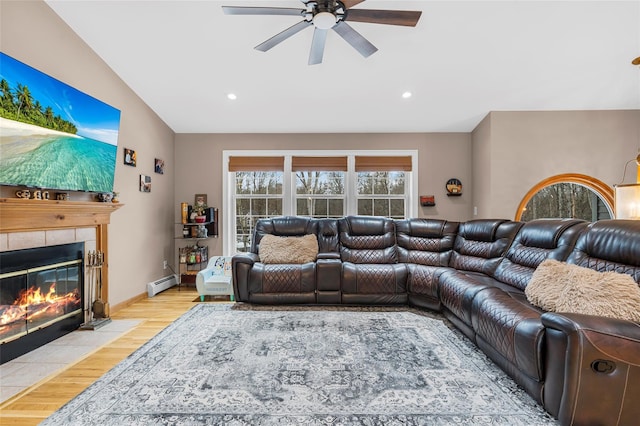 living area with a ceiling fan, light wood-style flooring, recessed lighting, a fireplace, and baseboard heating