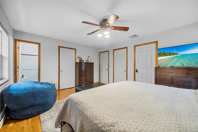 bedroom with light wood-type flooring, visible vents, multiple closets, baseboards, and ceiling fan