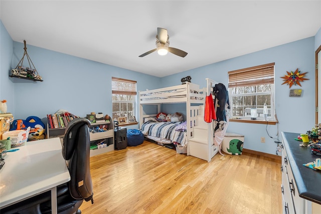 bedroom with baseboards, light wood-style floors, and a ceiling fan