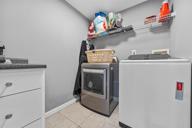 laundry room featuring laundry area, light tile patterned floors, baseboards, and independent washer and dryer