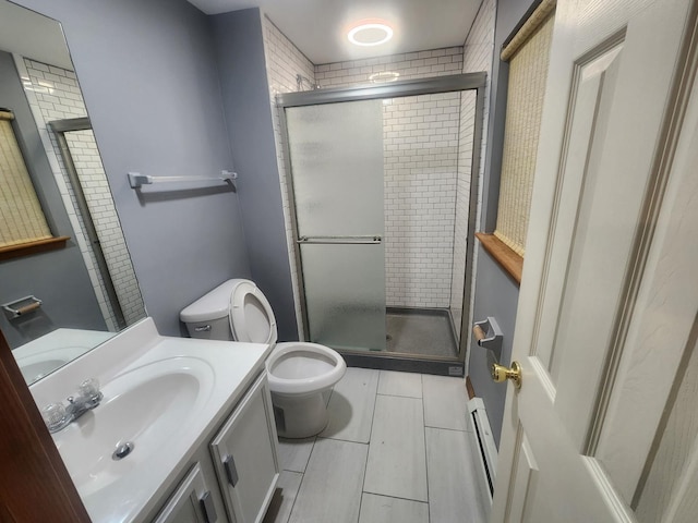 full bath featuring a shower stall, a baseboard heating unit, toilet, and vanity