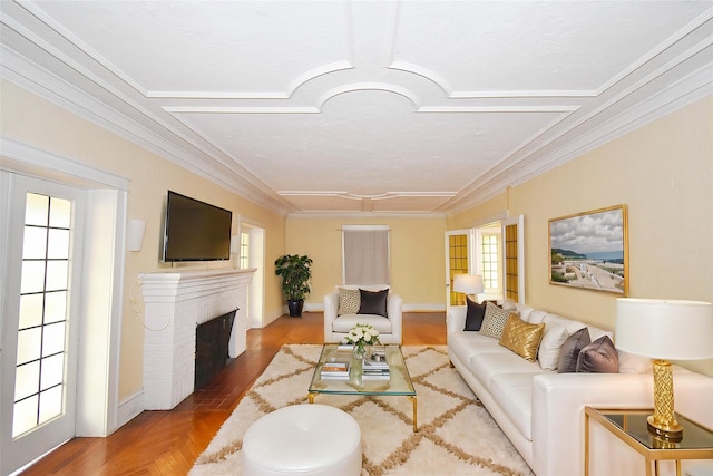 living room with ornamental molding, a brick fireplace, a wealth of natural light, and baseboards