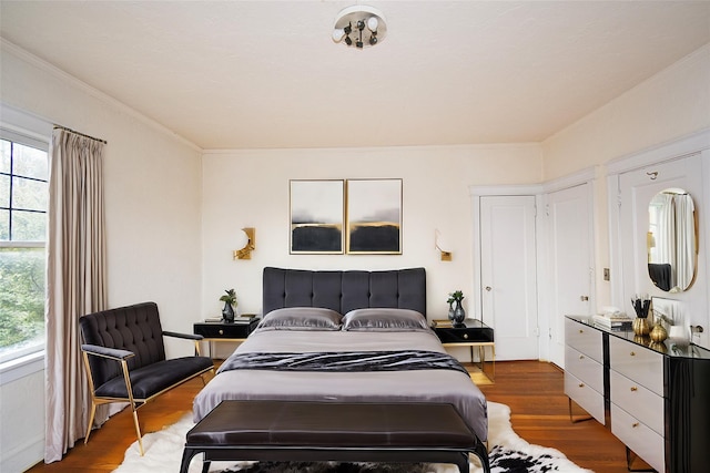 bedroom featuring wood finished floors and crown molding