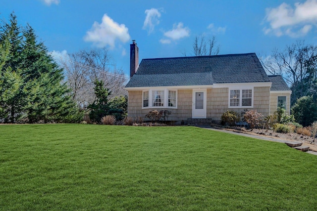 view of front of property with a shingled roof, a chimney, and a front lawn