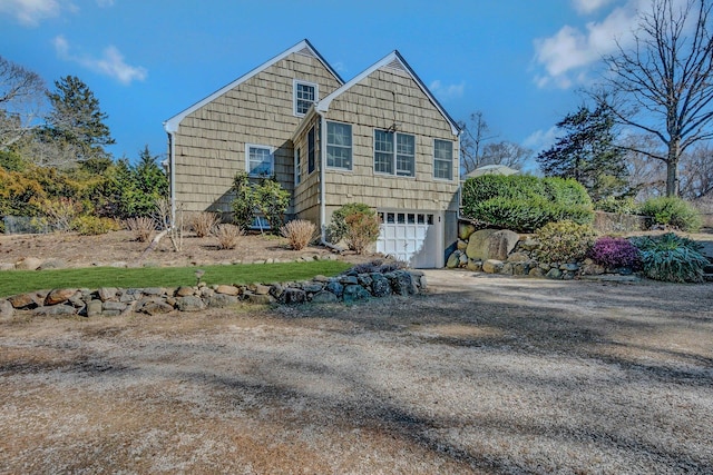 view of side of home featuring driveway and an attached garage