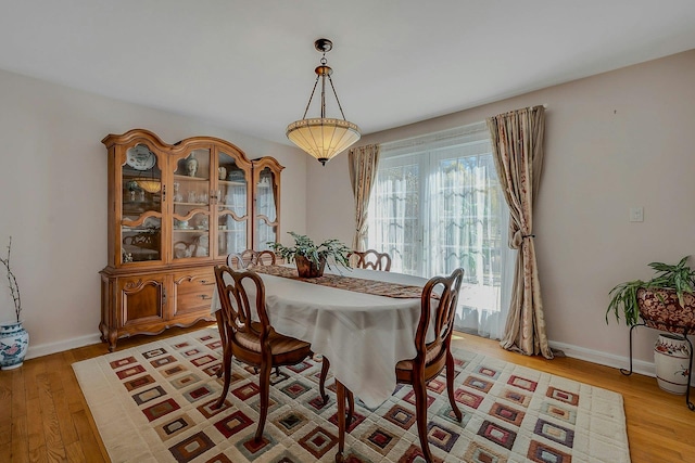 dining room featuring baseboards and light wood finished floors