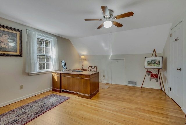 office space featuring lofted ceiling, ceiling fan, visible vents, baseboards, and light wood-style floors