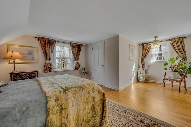 bedroom featuring light wood-type flooring, lofted ceiling, and baseboards