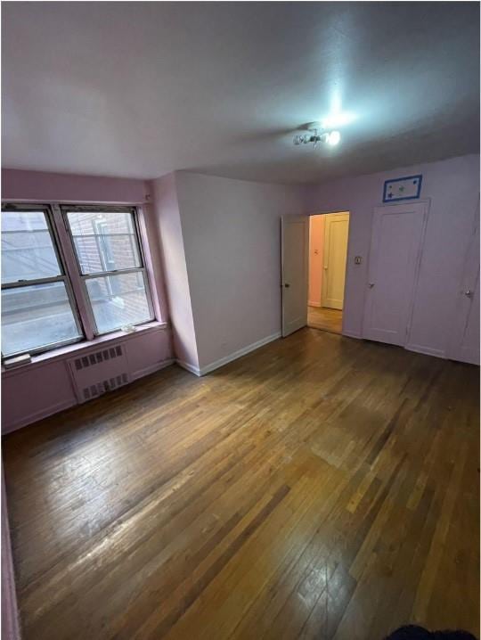 spare room featuring hardwood / wood-style flooring and baseboards