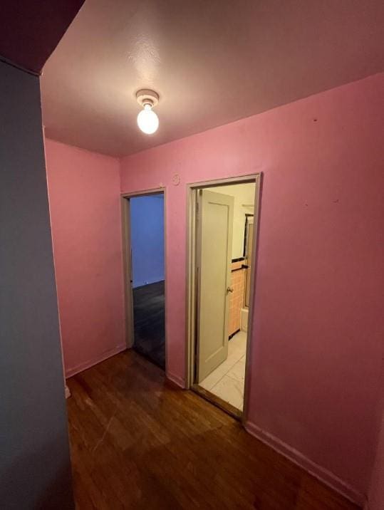 hallway with baseboards and wood finished floors