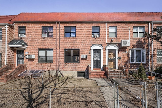 view of property featuring fence, cooling unit, and brick siding