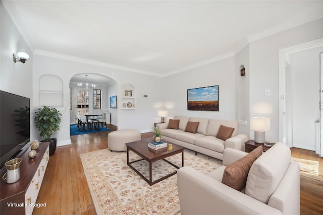 living area with light wood-style floors, baseboards, arched walkways, and ornamental molding