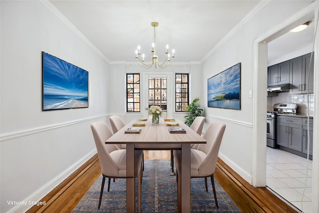 dining room featuring an inviting chandelier, light wood-style flooring, ornamental molding, and baseboards