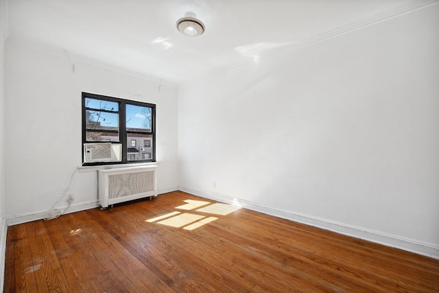 spare room featuring radiator, hardwood / wood-style flooring, cooling unit, and crown molding