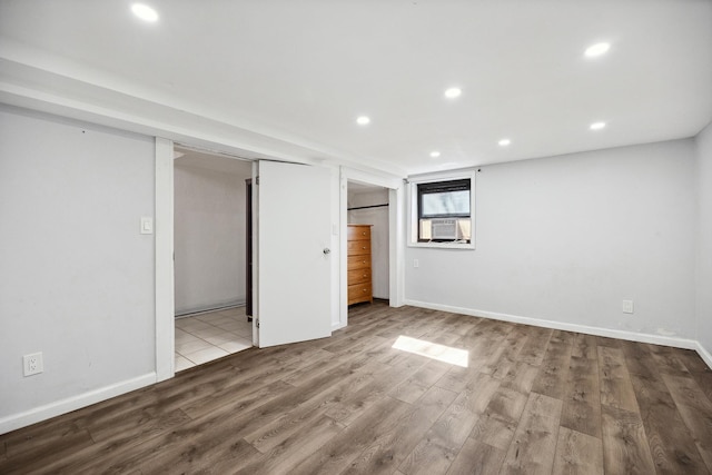 interior space with cooling unit, baseboards, wood finished floors, and recessed lighting