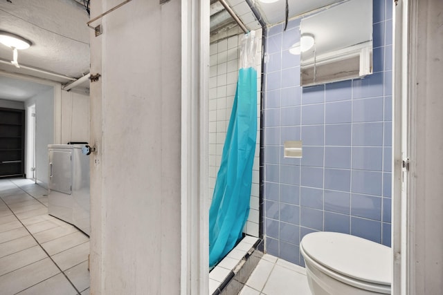 full bathroom with toilet, a shower with curtain, washer / clothes dryer, tile patterned floors, and tile walls