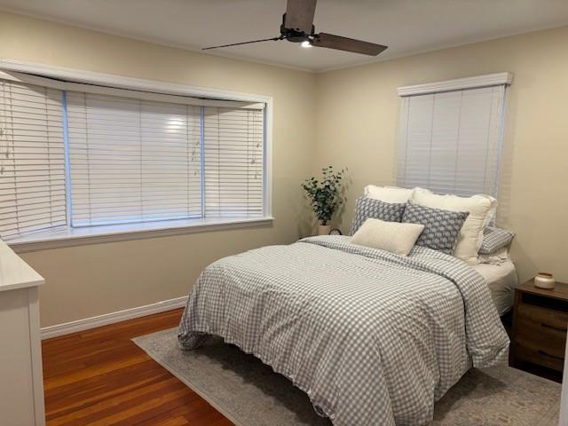 bedroom featuring ceiling fan, baseboards, and wood finished floors