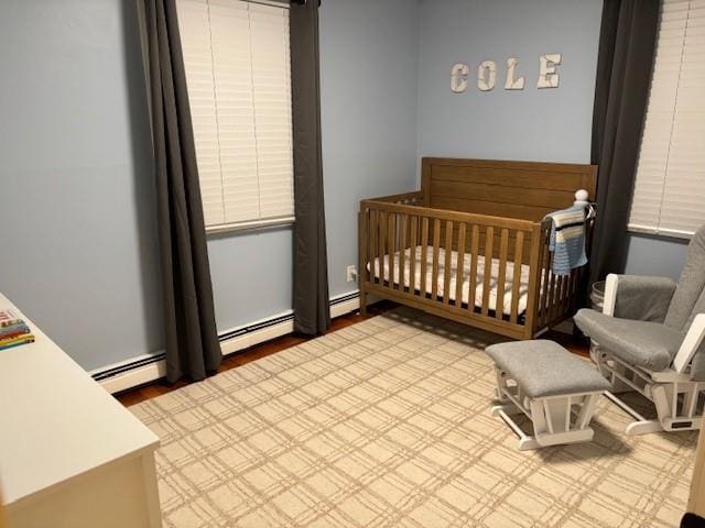 bedroom with a crib and a baseboard radiator