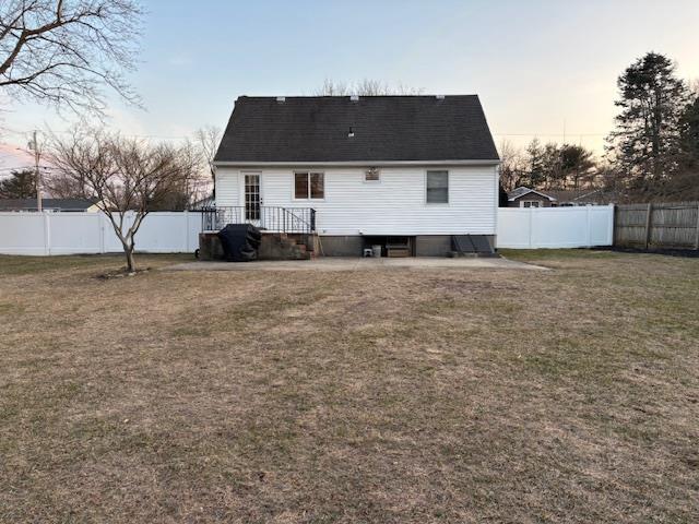 back of property featuring a lawn and a fenced backyard