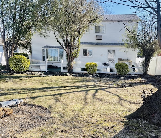 rear view of property with a yard and fence