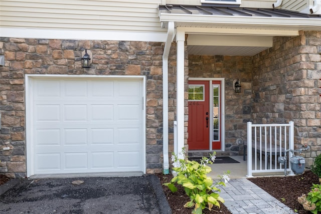 doorway to property featuring a standing seam roof, stone siding, and metal roof