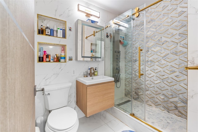 bathroom featuring a stall shower, toilet, marble finish floor, vanity, and tile walls