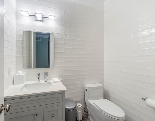 half bathroom with visible vents, vanity, and toilet