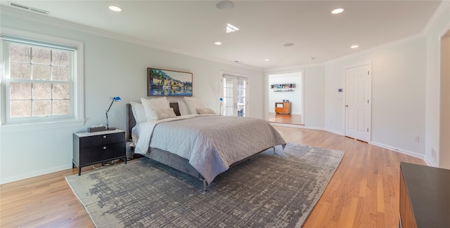 bedroom with light wood-type flooring, visible vents, crown molding, and baseboards