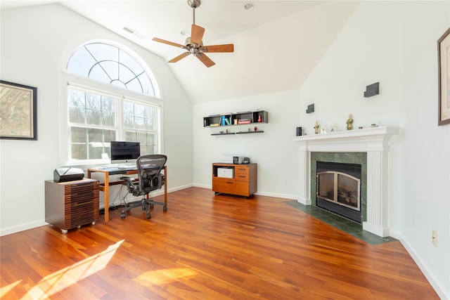 home office with high vaulted ceiling, a fireplace, wood finished floors, and visible vents