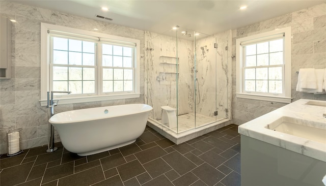 full bathroom featuring a healthy amount of sunlight, a marble finish shower, visible vents, and tile walls