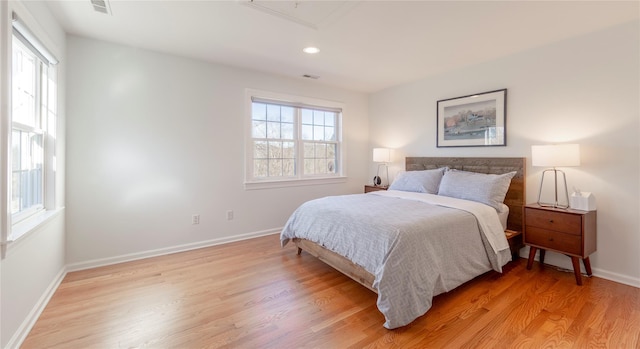 bedroom with attic access, visible vents, baseboards, light wood-type flooring, and recessed lighting