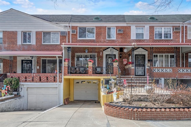 multi unit property featuring a garage, driveway, brick siding, and a shingled roof