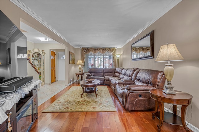 living room with crown molding, baseboards, and hardwood / wood-style flooring