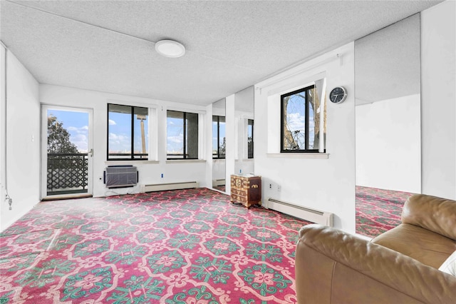 carpeted living area with a wall unit AC, baseboard heating, and a textured ceiling