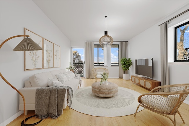 sitting room featuring vaulted ceiling, baseboards, and wood finished floors