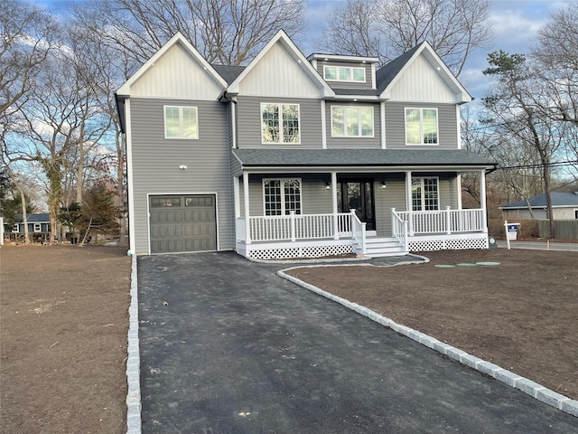 view of front of house with driveway, a garage, a shingled roof, covered porch, and board and batten siding