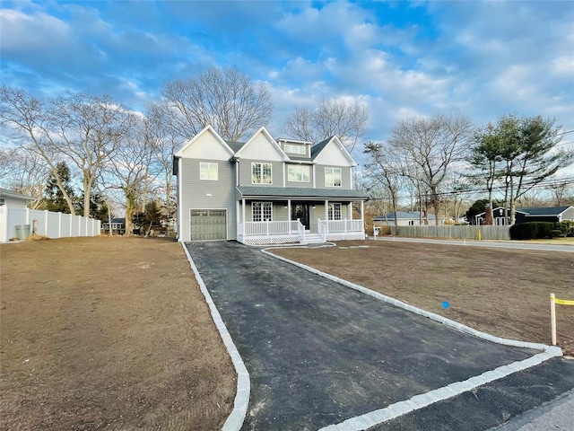 view of front of property with a porch, an attached garage, fence, driveway, and a front yard