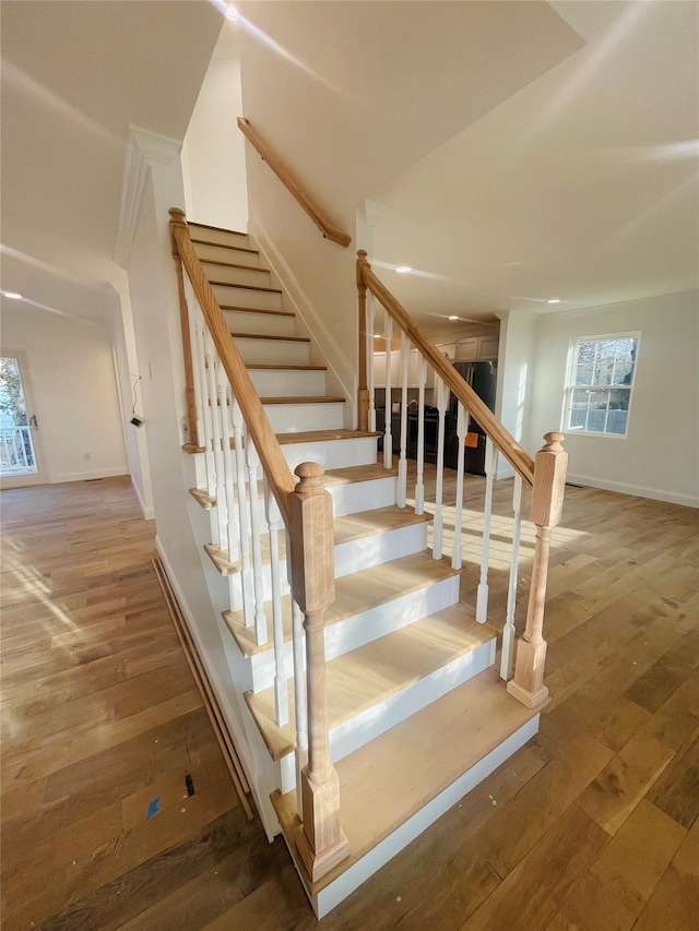 stairway featuring hardwood / wood-style flooring and baseboards