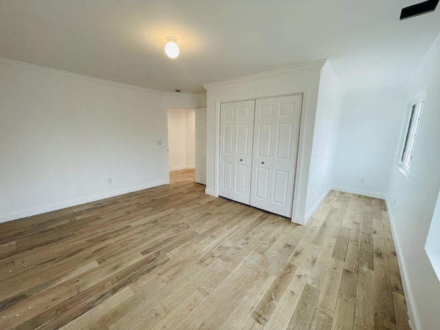 unfurnished bedroom with baseboards, light wood-style flooring, and crown molding