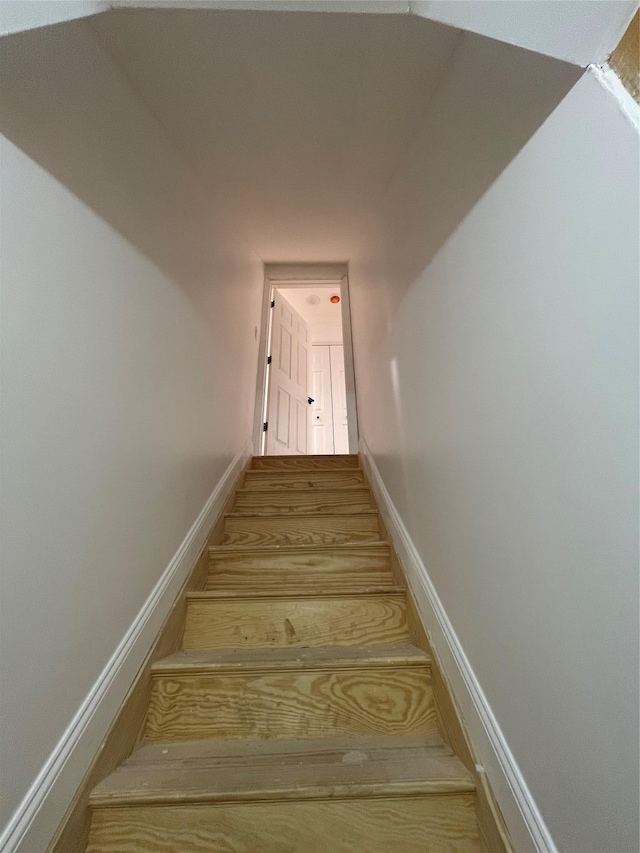 stairs featuring wood finished floors