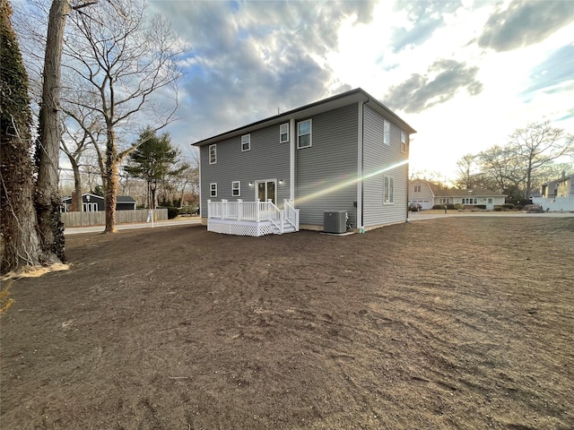 back of property with central AC unit and a deck